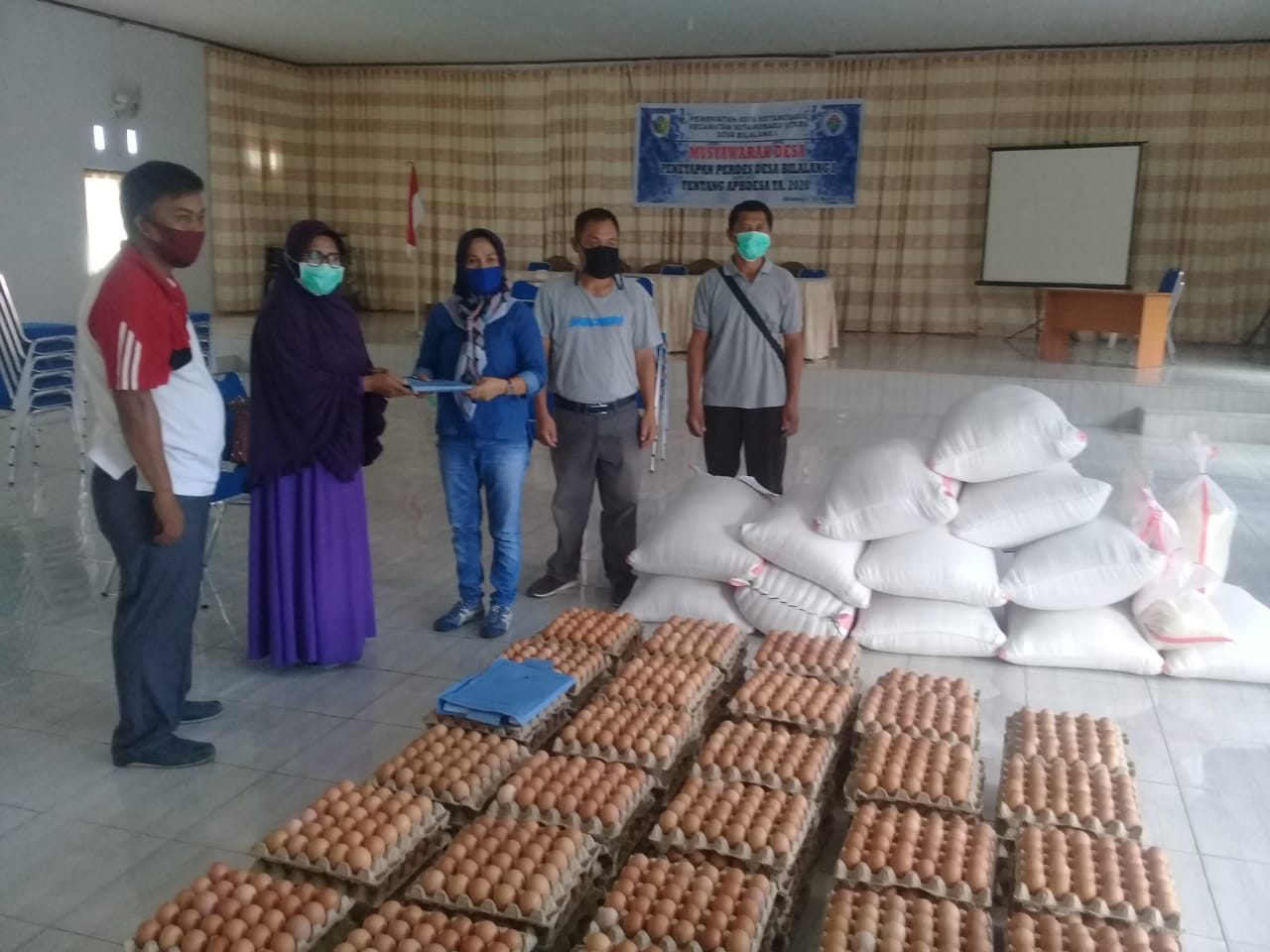 Penyerahan bantuan pangan kepada masyarakat terdampak Covid 19 pada kegiatan PDRP oleh Dinas Ketahanan Pangan kepada Sangadi Bilalang 1